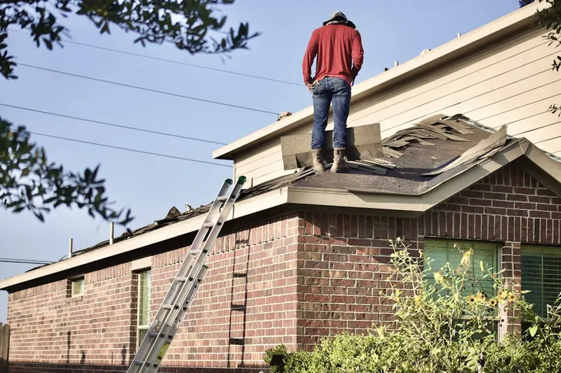 Professional roofer working on a residential roof in Flakes Crossing